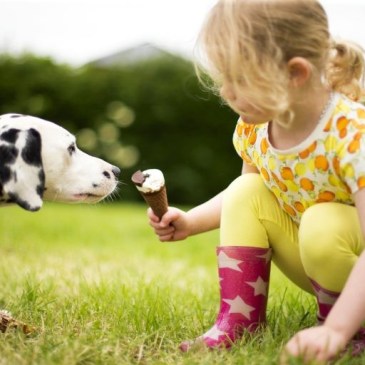 girl feeding ice cream to a dog